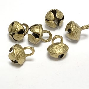 May include: Six gold-coloured metal bells with a loop on top. The bells have a textured surface and are approximately 1 inch in diameter.