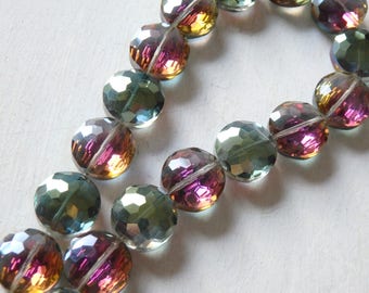May include: A strand of iridescent glass beads with a mix of green, purple, and gold tones. The beads are faceted and have a reflective finish.