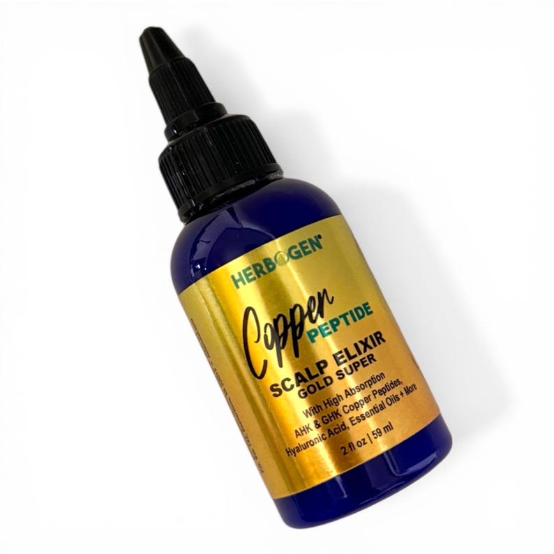 May include: A blue plastic bottle with a black pointed applicator cap and a gold label. The label reads HERBOGEN Copper PEPTIDE SCALP ELIXIR GOLD SUPER With High Absorption AHK & GHK Copper Peptides, Hyaluronic Acid, Essential Oils + More 2 fl oz | 59 ml.