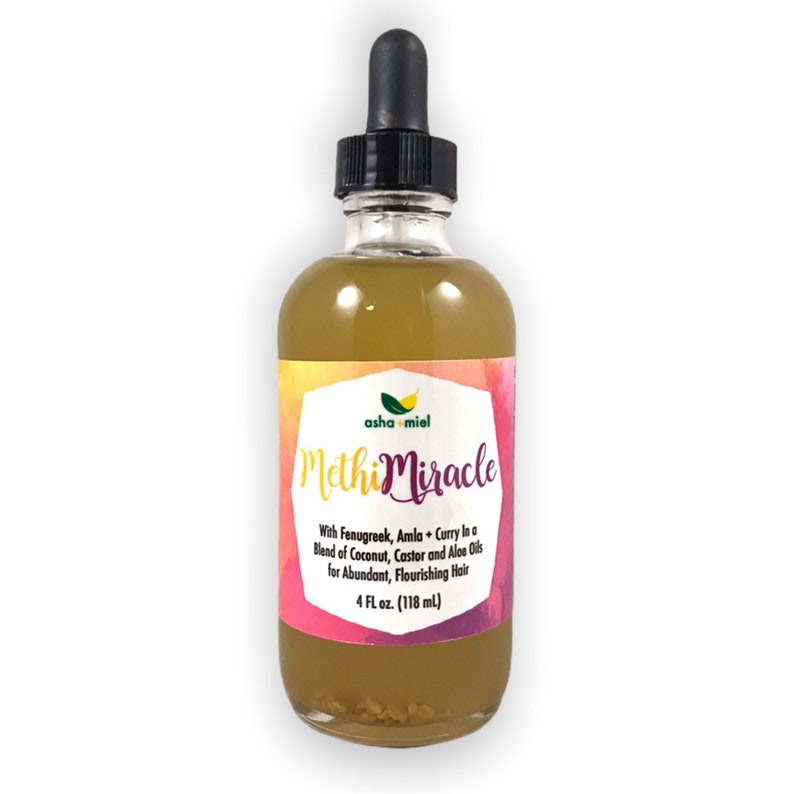 May include: A clear glass bottle with a dropper top filled with a yellow liquid. The label is pink, yellow, and green with the text "asha miel Methi Miracle" and the description "With Fenugreek, Amla + Curry In a Blend of Coconut, Castor and Aloe Oils for Abundant, Flourishing Hair 4 FL oz. (118 ml)"