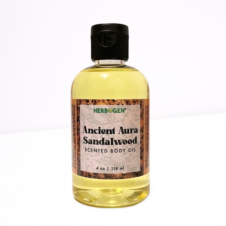 May include: A clear glass bottle with a black cap filled with a yellow liquid. The bottle has a label that reads "Herbogen" in green letters, "Ancient Aura Sandalwood" in black letters, and "Scented Body Oil" in smaller black letters. The label also says "4 oz | 118 ml".