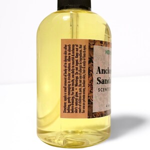 May include: A clear glass bottle with a yellow liquid inside. The bottle has a brown label with the text "Ancient Sandalwood Scented" on it. The label also includes directions for use and warnings.