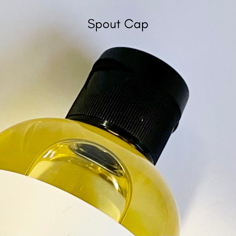 May include: A close-up of a yellow liquid bottle with a black spout cap. The cap has a textured surface.