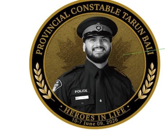 Könnte beinhalten: Eine kreisförmige Gedenktafel mit dem Porträt eines Polizeibeamten in Uniform. Der Text lautet PROVINCIAL CONSTABLE TARUN BALI, HEROES IN LIFE, 10-7 June 09, 2026 und Hey buddy, it's Bali. Ein goldenes Ahornblatt ist im Hintergrund zu sehen.