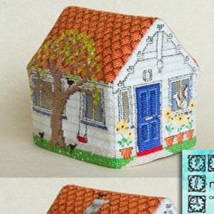 Op de afbeelding: Een kruissteekpatroon voor een klein huisje met een kersenboom ervoor. Het patroon is getiteld "Brestigea Village #1 Cherry Tree Cottage" en is afkomstig uit de collectie "Minute Matters" van Bli Jenks.