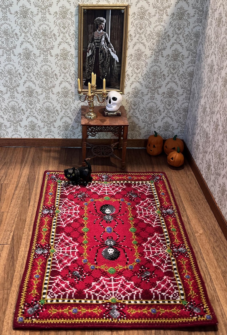 May include: A red and white Halloween-themed rug with a spiderweb design and black spiders. The rug has a gold and black border.