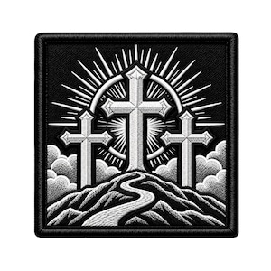 May include: A square embroidered patch featuring a black background with three white crosses standing atop a hill. A winding path leads up the hill toward the crosses, which are set against a circular sunburst design and stylized white clouds.