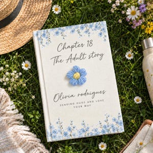 Peut inclure: Un livre à couverture rigide de couleur crème orné d'illustrations florales bleues en haut et en bas. Le texte indique Chapter 18 The Adult story, Olivia rodrigues, et SENDING HUGS AND LOVE YOUR WAY, avec une fleur crochetée bleue au centre.