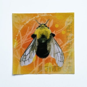 Może przedstawiać: Żółto-czarny trzmiel z przezroczystymi skrzydłami znajduje się na środku żółto-pomarańczowego tła. Tekst "May our hard work benefit all life on earth" jest napisany w kółko wokół trzmiela.