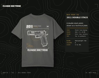 May include: A charcoal gray short-sleeve t-shirt featuring a white technical line drawing of a 2011 double stack pistol on the back. The graphic includes the text 2011 DOUBLE STACK, RANGE DOCTRINE, and a grid pattern with topographic contour lines.