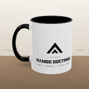 May include: A white ceramic mug with a black interior and a black handle. The front features a black triangular logo above the text RANGE DOCTRINE, with the words PEOPLE, PRINCIPLES, A HIGHER STANDARD printed in smaller black lettering below.