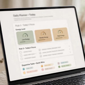 May include: A laptop screen displaying a digital daily planner interface with sections titled Daily Planner - Today, Pick 3 - Today's Focus, and Dopamine Tasks - Quick Wins. The layout features energy level gauges in green, tan, and brown color blocks.