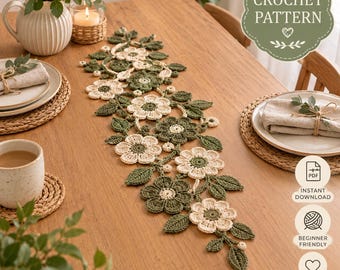 May include: A crochet table runner featuring a floral motif with cream and dark green yarn flowers and leaves. The text CROCHET PATTERN, INSTANT DOWNLOAD, BEGINNER FRIENDLY, and STEP BY STEP INSTRUCTIONS are visible on the image overlay.