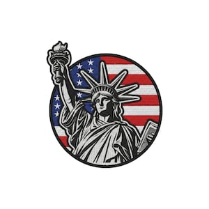 May include: A circular embroidered patch featuring a black and white illustration of the Statue of Liberty holding a torch and a tablet. The background consists of a red, white, and blue American flag design with white stars on a blue field.
