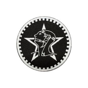 May include: A circular embroidered patch featuring a black background with a white five-pointed star. Centered within the star is a white line-art profile of a head wearing a helmet or hood. The border consists of a white and black cog-like pattern.