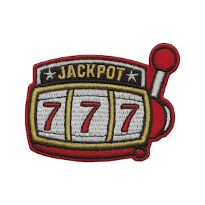 May include: An embroidered patch shaped like a slot machine with a red frame and a white screen displaying three red number sevens. The word JACKPOT is stitched in gold letters above the reels, flanked by two small white stars on a black background.