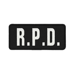 以下が含まれることがあります： 黒い背景に白い刺繍で「R.P.D.」と記された長方形の刺繍ワッペン。太くはっきりとしたフォントと縁取りが施されており、縫い付けやアイロン接着によって布製品に取り付けることができるデザインとなっている。