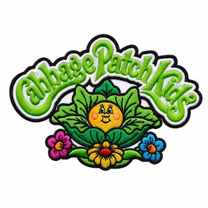 May include: An embroidered patch featuring the text Cabbage Patch Kids in bright green letters with a black border. Below the text is a yellow face with pink cheeks nestled inside green cabbage leaves, flanked by a pink flower and a blue flower.