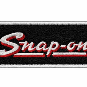 Pode incluir: Um emblema retangular bordado com fundo preto e borda branca. O texto Snap-on é costurado em branco com uma sombra projetada vermelha e um sublinhado vermelho, apresentando uma fonte de estilo manuscrito centralizada no emblema.