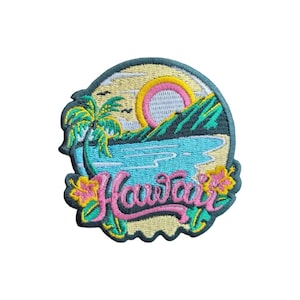 Puede incluir: Un parche bordado circular que muestra un paisaje tropical con una palmera, un sol rosa brillante, montañas verdes y agua azul. La palabra Hawaii está bordada en cursiva rosa en la parte inferior, acentuada por flores de hibisco amarillas.