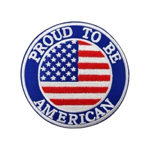 May include: A circular embroidered patch featuring the United States flag in the center with red, white, and blue colors. A thick blue border surrounds the flag with the white text PROUD TO BE AMERICAN written in a circular font around the edge.