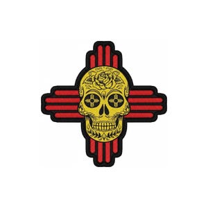 May include: An embroidered patch featuring a yellow sugar skull with black line details, a rose on the forehead, and Zia sun symbols in the eye sockets. The skull is centered over a red and black Zia cross shape with a thick black border outline.
