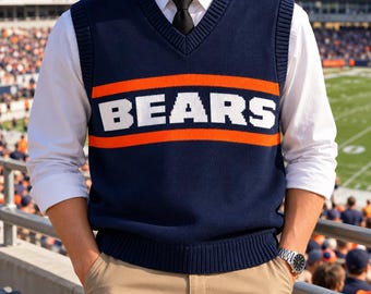 May include: A navy blue V-neck sweater vest featuring the word BEARS in white block letters centered between two horizontal orange stripes. The vest is worn over a crisp white long-sleeved button-down shirt with a black necktie.