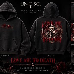 May include: A black oversized hoodie featuring a small red rose graphic on the front chest and a large back print of two skeletons kissing surrounded by red roses and the text "LOVE ME TO DEATH" with crescent moon symbols.
