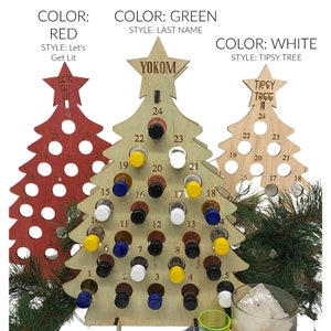 May include: Three wooden Christmas tree-shaped advent calendars. One is red with the text "Let's Get Lit", one is natural wood with the name "Yokom", and one is white with the text "Tipsy Tree". Each tree has numbered holes for small bottles.