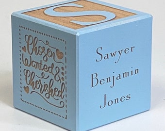 Puede incluir: Un bloque de madera azul claro con la letra "S" en un lado y las palabras "Chosen Wanted & Cherished" en otro lado. El otro lado del bloque tiene el nombre "Sawyer Benjamin Jones" grabado.