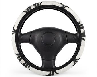 Coprivolante nero con dettagli ornamentali a forma di fiore e arco su sfondo bianco.