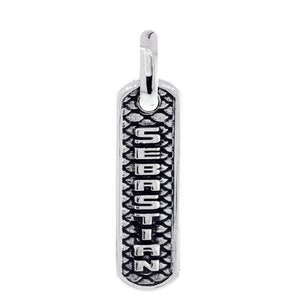 May include: A silver-colored pendant with the name "SEBASTIAN" engraved vertically. The pendant has a rectangular shape with a textured, scale-like pattern on the front. A small loop is at the top for attaching to a chain.