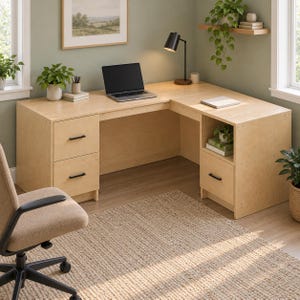 May include: An L-shaped light wood desk featuring two stacked drawers on the left side with black handles and a single drawer with an open shelf above it on the right side. The desk surface holds a laptop, a black desk lamp, and a notebook.