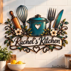 Könnte beinhalten: Ein dekoratives Wandschild mit dem Text Rachel's Kitchen auf einem Banner. Das Design umfasst ein braunes Nudelholz, einen schwarzen Schneebesen, einen türkisfarbenen Topf mit Herzausschnitt, eine schwarze Gabel und ein türkisfarbenes Messer, umrahmt von Blumen.