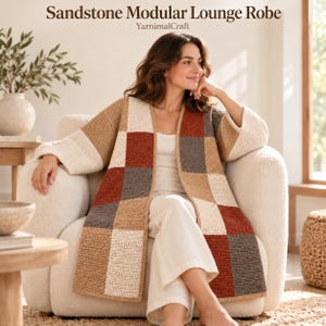 May include: A Sandstone Modular Lounge Robe by YarnimalCraft featuring a patchwork design of crocheted squares in cream, tan, rust orange, and charcoal gray. The open-front robe has long, wide sleeves and a straight hem, worn over a white top and pants.