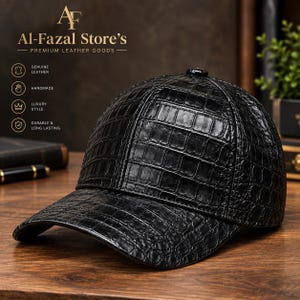Puede incluir: Una gorra de béisbol negra con un patrón de piel de cocodrilo texturizado. La gorra tiene una corona estructurada y una visera curva. El texto en la imagen incluye el logotipo de Al-Fazal Store's, Premium Leather Goods, Genuine Leather, Handmade, Luxury Style y Durable & Long Lasting.