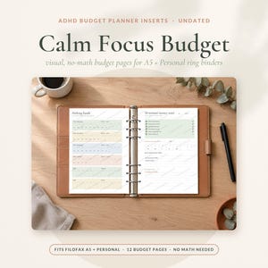 Könnte beinhalten: Ein offener Ringbuchplaner aus beigem Leder mit undatierten Budget-Einlagen in Pastellfarben. Die linke Seite ist mit Sinking funds und die rechte Seite mit 10 minute money reset betitelt. Der Text Calm Focus Budget ist deutlich zu erkennen.