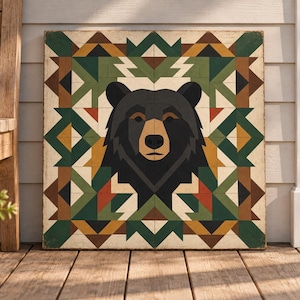 May include: A square wooden wall art piece featuring a stylized black bear head centered against a geometric pattern of triangles and diamonds in shades of forest green, mustard yellow, dark brown, cream, and burnt orange on a flat surface.