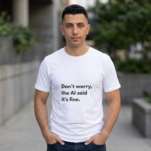 May include: A white short-sleeved t-shirt featuring the black printed text "Don't worry, the AI said it's fine." and the smaller text "THINKERS & MAKERS" positioned below the main phrase on the front of the garment.