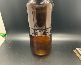 May include: A brown glass bottle with a white label that says "WATER" on it. The bottle is a full quart.