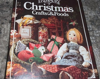 May include: A vintage book titled "Treasury of Christmas Crafts & Foods" with a cover image of a doll sitting in a basket with various Christmas crafts and foods. The book is from Better Homes and Gardens.