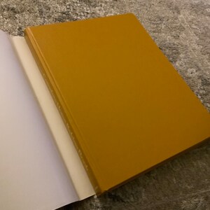 May include: A closed, yellow hardback book with a white spine.