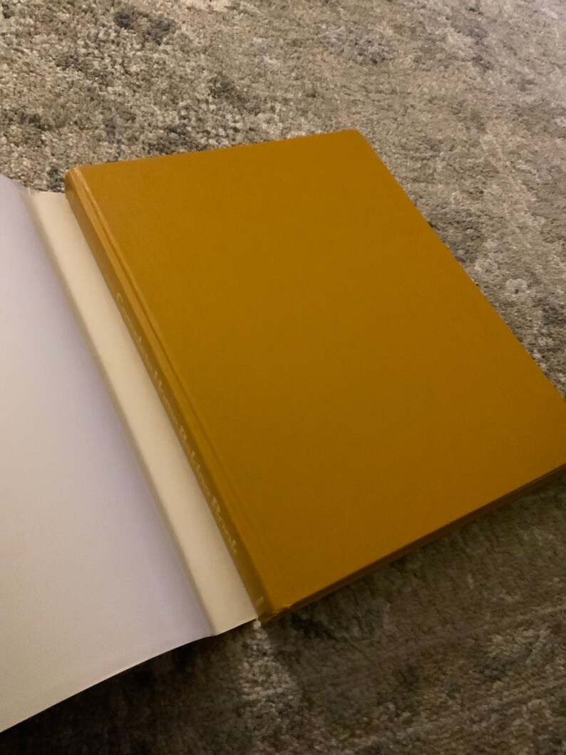 May include: A closed, yellow hardback book with a white spine.