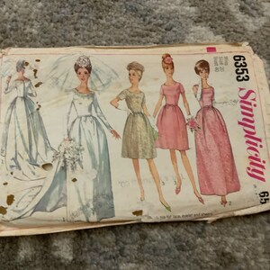 May include: Vintage Simplicity sewing pattern number 6353 for a wedding dress and bridesmaid dresses. The pattern includes four different styles, all with long sleeves and a fitted bodice. The pattern is for sizes 10 to 20, bust 30 to 40.