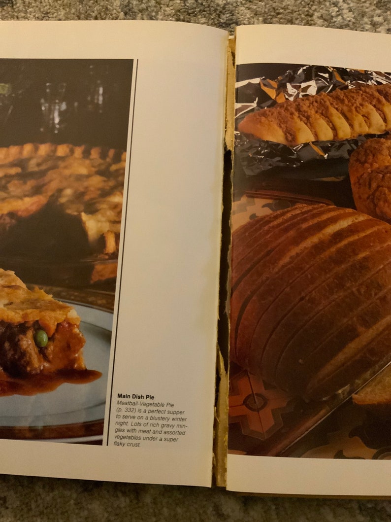 May include: A close-up of a meatball and vegetable pie with a flaky crust. The pie is on a blue and white plate. The text "Main Dish Pie Meatball-Vegetable Pie (p. 332) is a perfect supper to serve on a blustery winter night. Lots of rich gravy mingles with meat and assorted vegetables under a super flaky crust." is visible in the image.