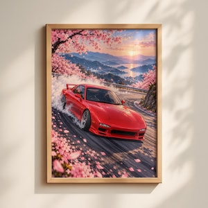 May include: A framed wall art print featuring a bright red sports car drifting on a winding mountain road. The scene is surrounded by blooming pink cherry blossom trees, with a sunset landscape of distant mountains and water in the background.
