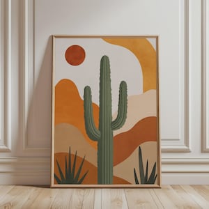 Op de afbeelding: Een rechthoekige wandkunstprint met een centrale groene saguaro-cactus en kleinere stekelige planten op de voorgrond. De achtergrond toont abstracte glooiende heuvels in tinten oranje en beige met een effen donkeroranje cirkelvormige zon.
