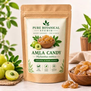 Könnte beinhalten: Ein brauner Kraftpapierbeutel mit Amla-Bonbons von Pure Botanical Studio. Das Etikett zeigt eine Holzschale mit bernsteinfarbenen Bonbons, grüne Amla-Früchte und Text, darunter Nature's Goodness, Phyllanthus emblica und Natural & Hand Picked.