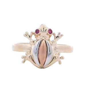 May include: A gold ring with a frog design. The frog is made of two-toned gold and has red ruby eyes.