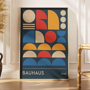 May include: A rectangular wall art print featuring a dark blue background with various geometric shapes in red, yellow, blue, and beige. The composition includes circles, semicircles, and horizontal lines. The text BAUHAUS and 1920 appear at the bottom.